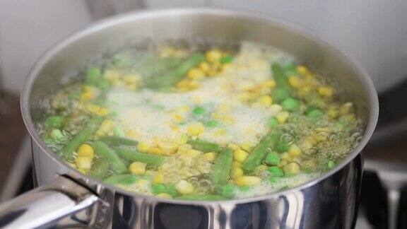 豌豆、玉米和四季豆在铁锅中水煮