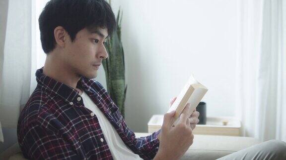 一个年轻人正在他的公寓里看书