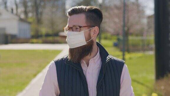 一名戴着医用口罩的男子正在穿过城市的街道