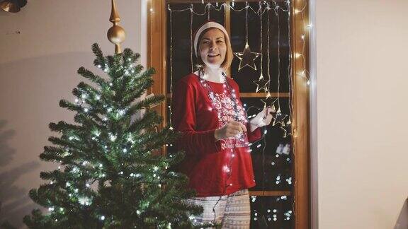活泼无忧无虑的女人戴着圣诞树灯在客厅跳舞