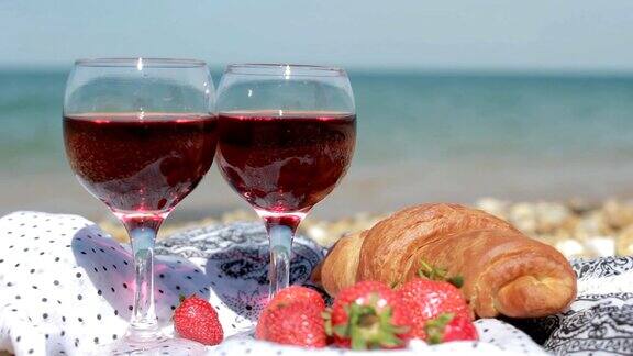 两杯红酒水果和羊角面包还能看到美丽的海景