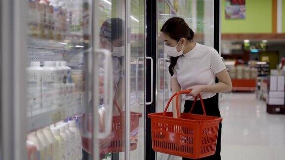 年轻妇女或女孩戴口罩在超市购买食品