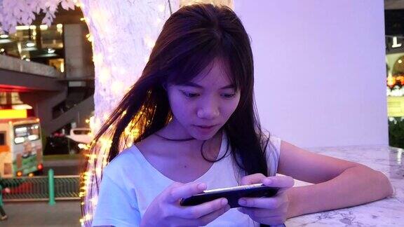 年轻女子在用智能手机背景是城市夜晚