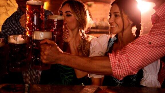 年轻的朋友们穿着德国服装喝着啤酒庆祝啤酒节