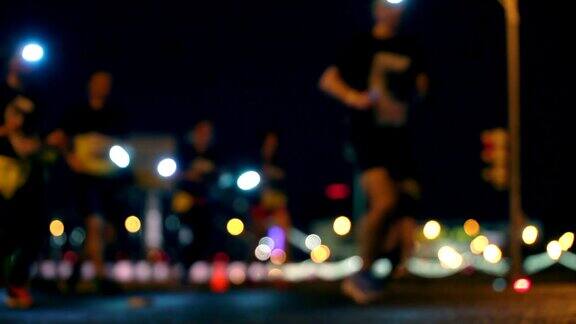 夜城跑LED灯下的人群跑午夜跑每年夏季举行的短距离跑马拉松比赛模糊中认不出的人