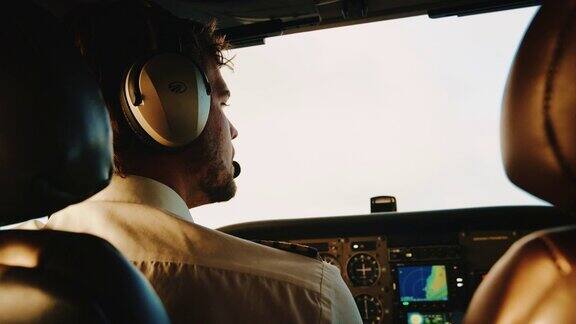 飞行员在日出时驾驶小型飞机观点驾驶舱视图