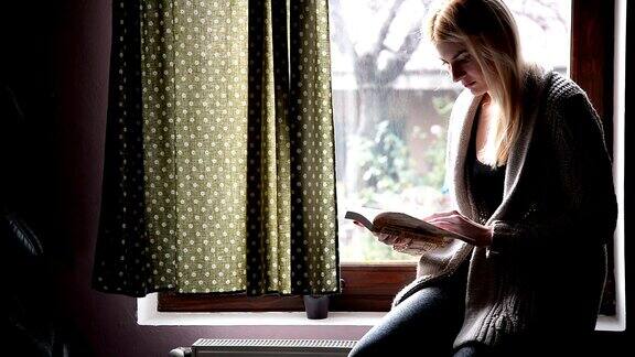 在窗边看书的女人