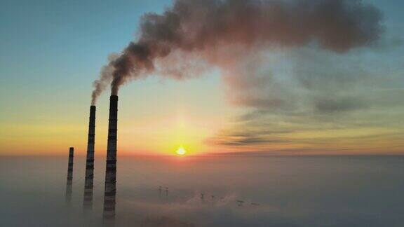 在日出时鸟瞰煤电厂的高管黑烟上升污染大气