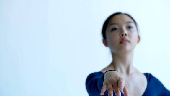 一个年轻美丽的芭蕾舞演员在表演舞蹈举起她的手镜头聚焦在手的特写