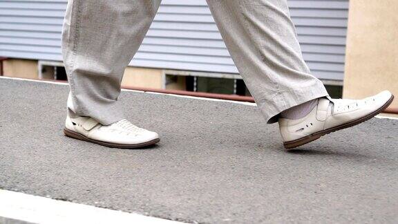 一个小伙子穿着白色的鞋子慢慢地自信地走在镇上的小路上