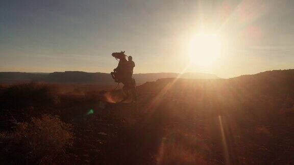 在亚利桑那州北部纪念碑谷部落公园附近的纳瓦霍保留区年轻的美国土著纳瓦霍男孩骑着他的无鞍马