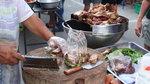 一名泰国男子将熟肉切成薄片准备在泰国街头食品市场出售近距离