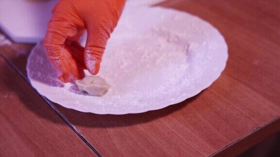 一个手工生饺子和面粉放在盘子里