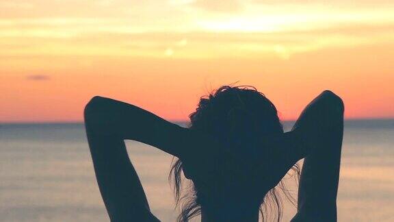 一个女人的剪影在日落与海洋