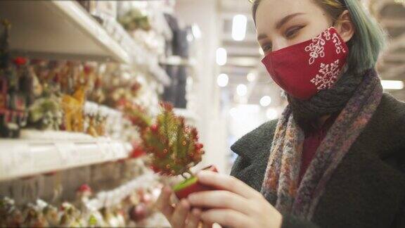 2019冠状病毒病期间年轻女性戴着防护口罩在圣诞购物
