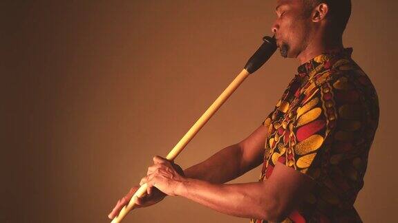 非裔美国男子音乐家演奏长笛在棕色背景拷贝空间