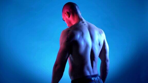 英俊的健身教练弯曲肌肉躯干和显示六个腹肌