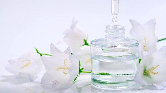香水精油产品从化妆吸液器滴到装有香水的玻璃瓶皮肤和身体护理芳香草药和鲜花液体美容和制药