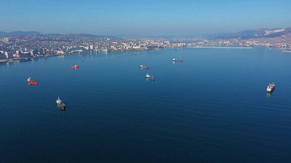 鸟瞰图船只漂在平静的蓝色海面上对着海岸的城市