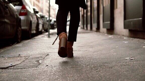 近景时尚的女人走在小街上女孩穿着高跟鞋穿过城市慢动作
