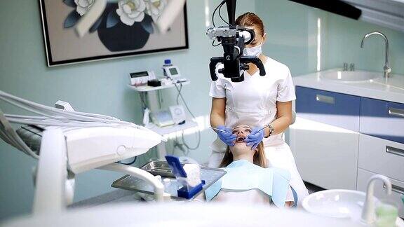 女牙医使用牙科工具-显微镜镜子和探针在牙科诊所治疗病人的牙齿医学、牙科和保健概念牙科设备