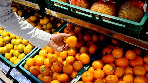 男人在超市挑选橘子