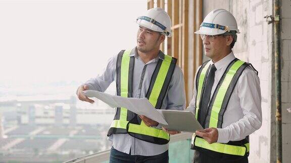 两名建筑工程师带着图纸在建筑工地工作