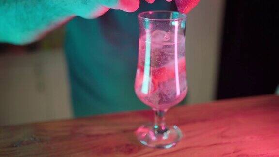 一个面目全非的酒保用草莓装饰鸡尾酒杯