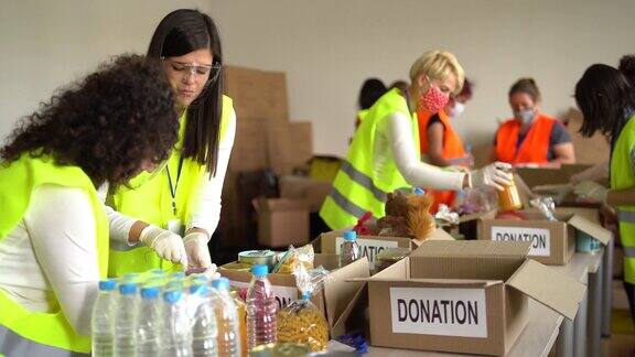 慈善组织在大流行时期在仓库收集食物捐赠