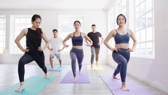 年轻的亚洲体育有吸引力的人练习瑜伽课与教练亚洲女性群体在健身室锻炼健康的生活方式