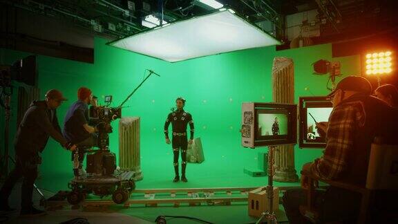 在大电影制片厂专业摄制组拍摄大片导演命令摄影师开始拍摄绿色屏幕CGI场景与演员穿着动作捕捉服和头部钻机