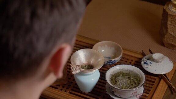 茶师将热水从茶壶倒入盖碗热杯子里的蒸汽绿茶
