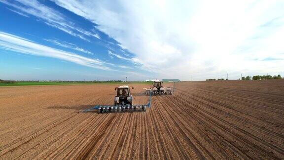 拖拉机在耕地上播种播种玉米和向日葵种子蓝色拖拉机带圆盘耙在耕地上