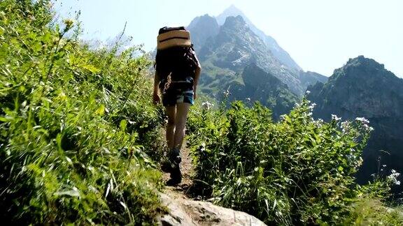 一名女徒步旅行者背包爬山