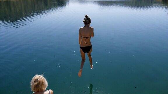 苗条的女孩跳入湖中