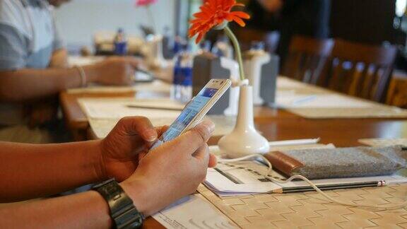 商人的手在会议桌上使用智能手机