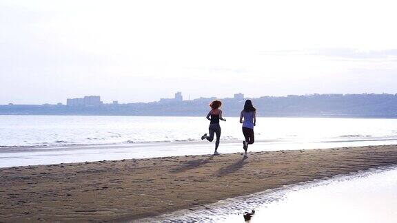 两个女人正沿着一条大河的沙岸慢跑