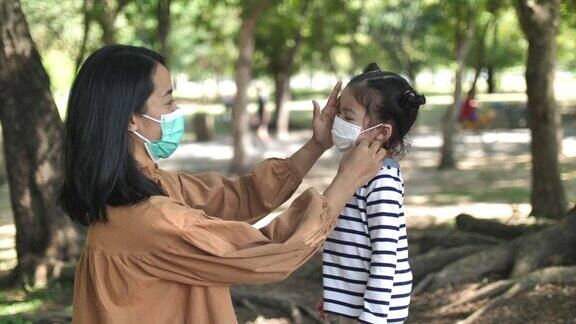母亲给女儿戴上医用口罩