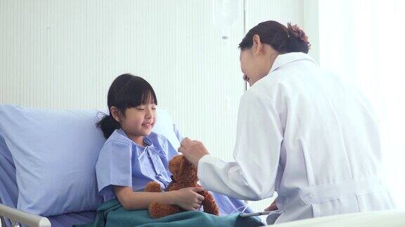 日本医生来医院病房用平板电脑检查泰国女孩的病情