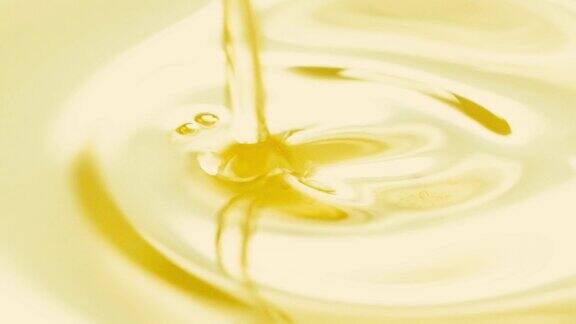 特写倒金色橄榄油液体在慢镜头健康的食物背景
