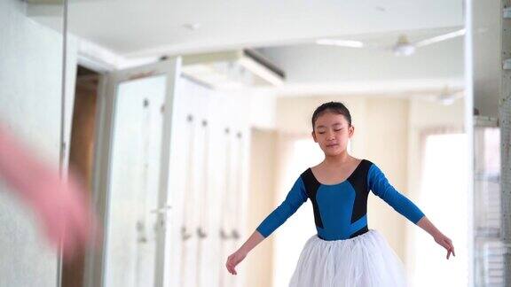 小女孩在舞蹈工作室练习芭蕾舞动作