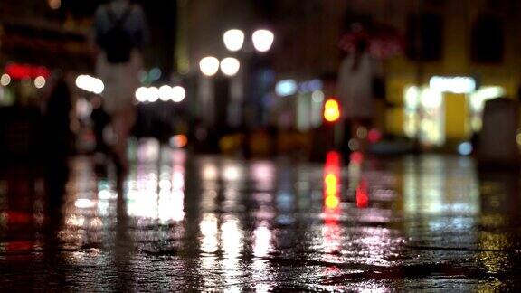 抽象明亮模糊的背景与雨滴落在多彩的沥青照明路灯和交通灯身份不明的女孩在雨夜的城市街道上积极的生活方式休闲季节天气生活方式