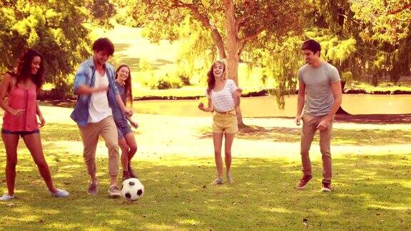 快乐的朋友们在公园里踢足球