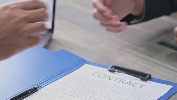 商务人士握手后签署协议合同商业成功合作伙伴关系公司业务工作面试概念
