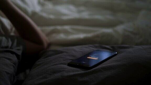 在床上睡觉的男人被手机闹钟吵醒
