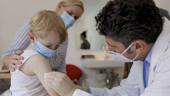小儿科医生正在给小男孩注射流感疫苗