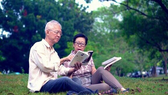 一对亚洲老夫妇在公园看书花宝贵的时间永远不要停止学习新东西