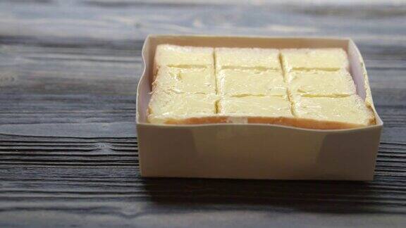 面包抹上一片黄油放在木桌上早餐食物配着奶酪奶油美味可口动来动去