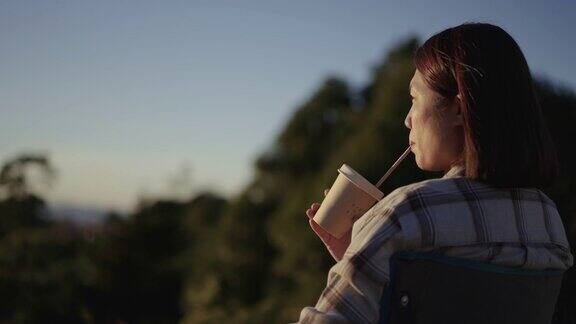 女人在户外放松与咖啡杯在山上的日落时间