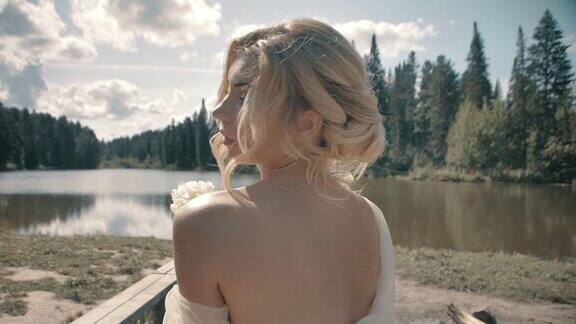 穿着白裙子的金发女孩坐在湖边